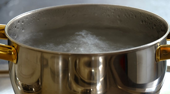 Unclog a kitchen sink using boiling water