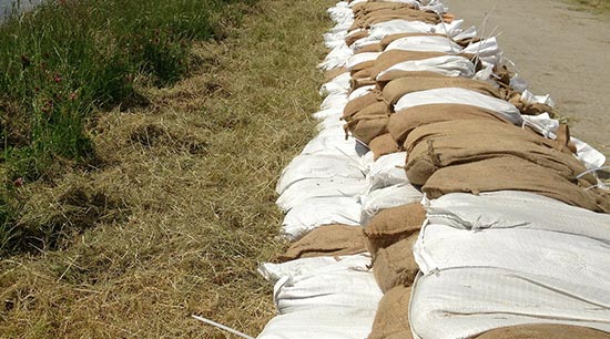 Prevent home flooding from rising stormwater using sandbags as a water barrier